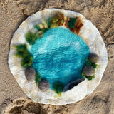 Rockpool, a round felt mat with a turquoise pool at its center, ringed by felt rocks, seaweed and a sandy shore · view 2