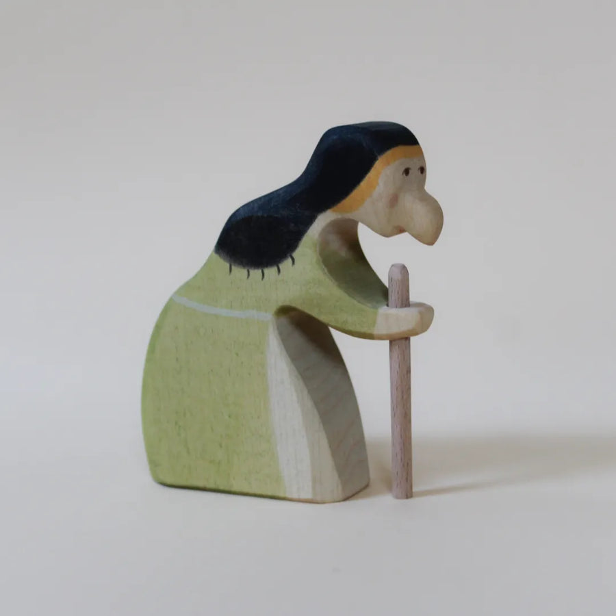 Juharka wooden witch stooped over a walking stick, in a sage green dress with black hair