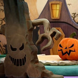 The Mako grasping tree with its carved face, beside a jack-o-lantern and the witch house · view 2