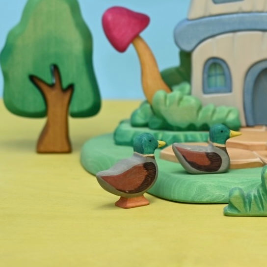 Close view of the wooden mallard duck's painted green head and yellow bill