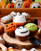 Four felt Halloween cupcakes topped with a ghost, a green monster, a white skull, and a jack-o-lantern · view 1