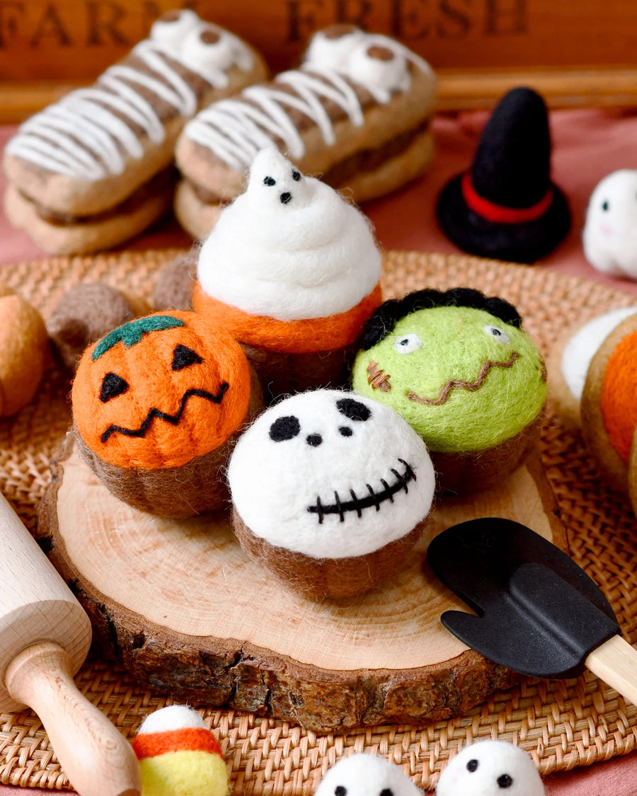 Second view of the four felt Halloween cupcakes showing the needle-felted toppers
