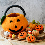Orange felt jack-o-lantern bag surrounded by felt Halloween food including pumpkins, cookies, and a cupcake · view 1