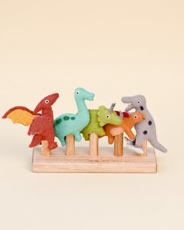 Five hand-felted dinosaur finger puppets on a wooden five-rod stand